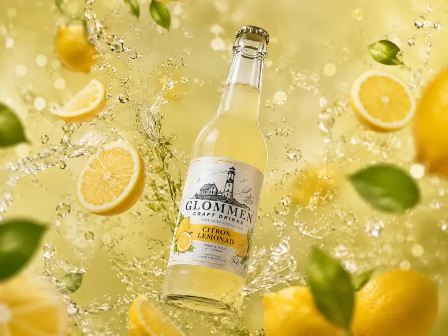 Glommen Citron Lemonad omgiven av citroner och vattensplash